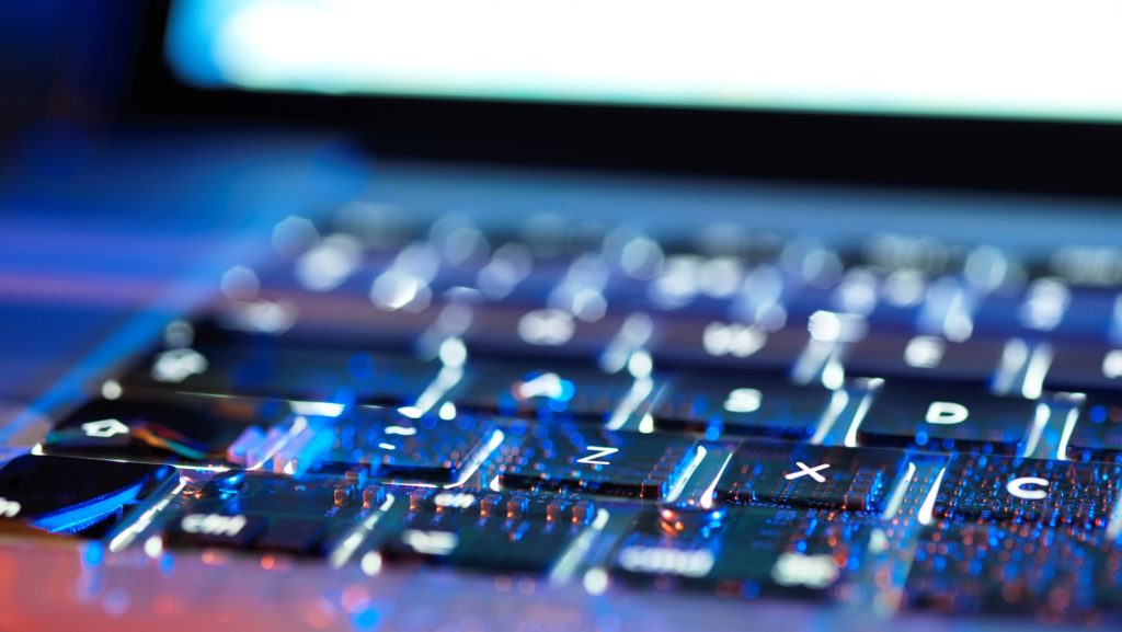 Double exposure of a laptop computer keyboard exposing the electronics underneath.